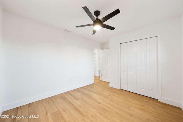 unfurnished bedroom with a closet, light hardwood / wood-style floors, and ceiling fan