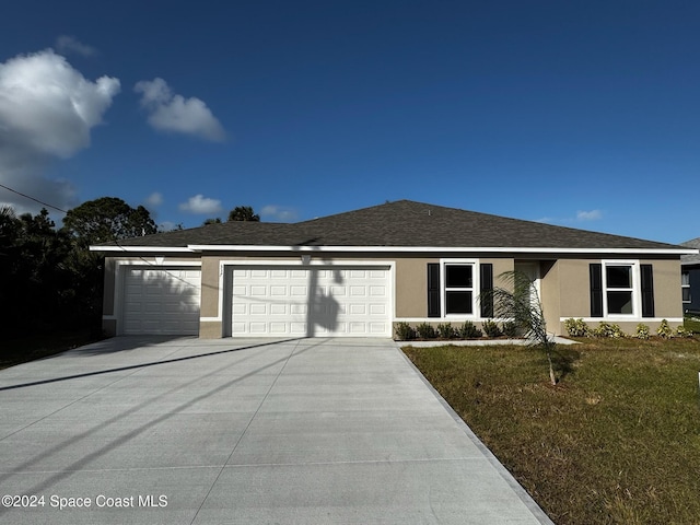 537 Macon St SW, Palm Bay, FL 32908 - single story home with stucco siding, a garage, driveway, a front lawn, and roof with shingles