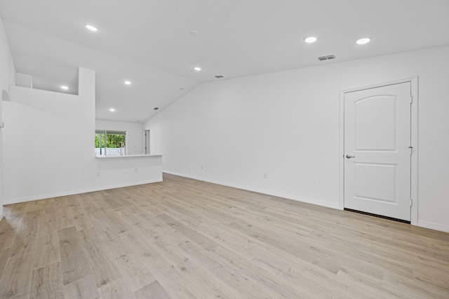 unfurnished living room with lofted ceiling and light wood-type flooring