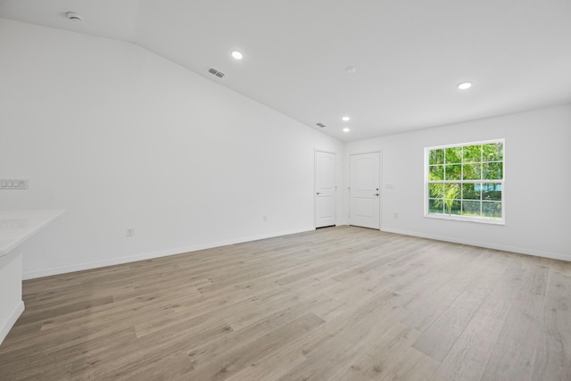 empty room featuring light hardwood / wood-style floors and lofted ceiling