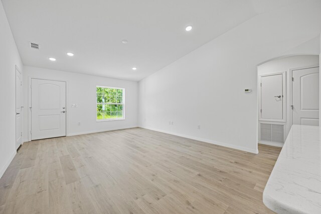 unfurnished living room with light hardwood / wood-style floors and lofted ceiling