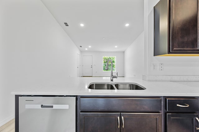 kitchen featuring light stone countertops, light wood-type flooring, dark brown cabinetry, sink, and dishwasher