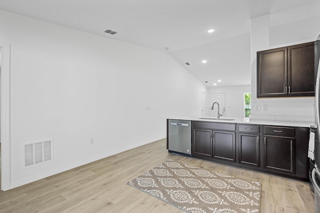 kitchen featuring dishwasher, light hardwood / wood-style floors, vaulted ceiling, and sink