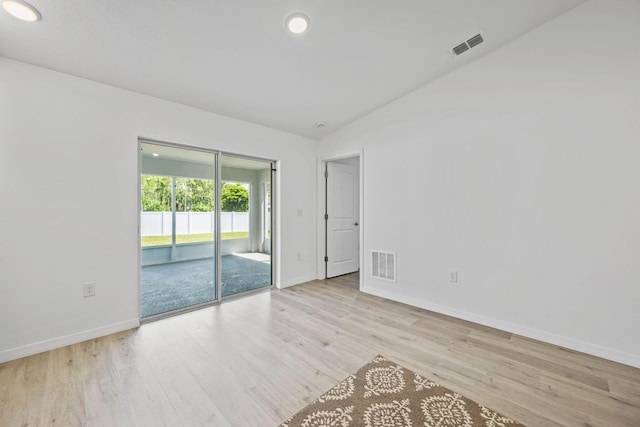 unfurnished room with light hardwood / wood-style floors and vaulted ceiling