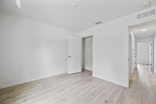 unfurnished bedroom with light hardwood / wood-style floors and a closet