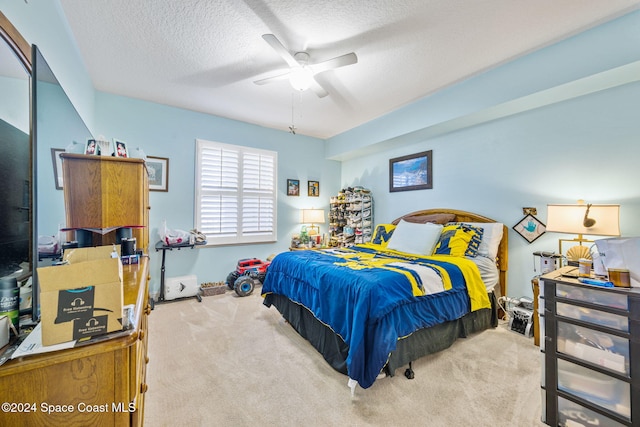 bedroom with carpet flooring, ceiling fan, and a textured ceiling