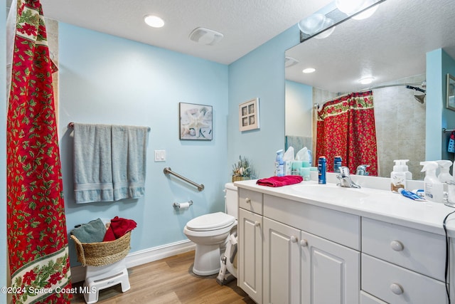 bathroom featuring a shower with curtain, a textured ceiling, toilet, vanity, and hardwood / wood-style flooring