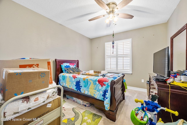 carpeted bedroom featuring ceiling fan and a textured ceiling