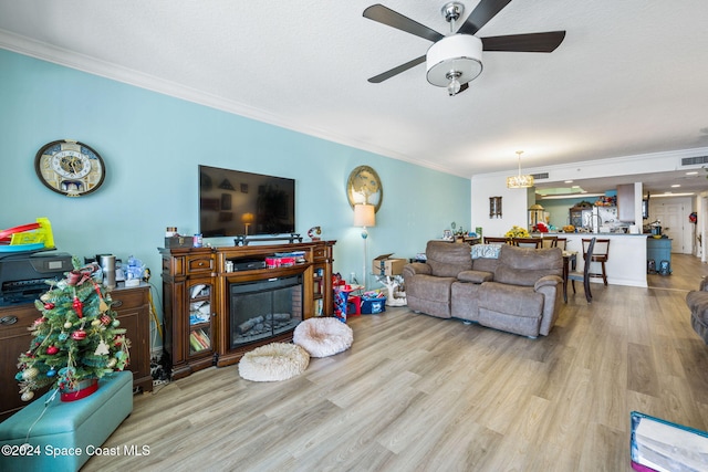 living room with light hardwood / wood-style floors, ceiling fan, and ornamental molding