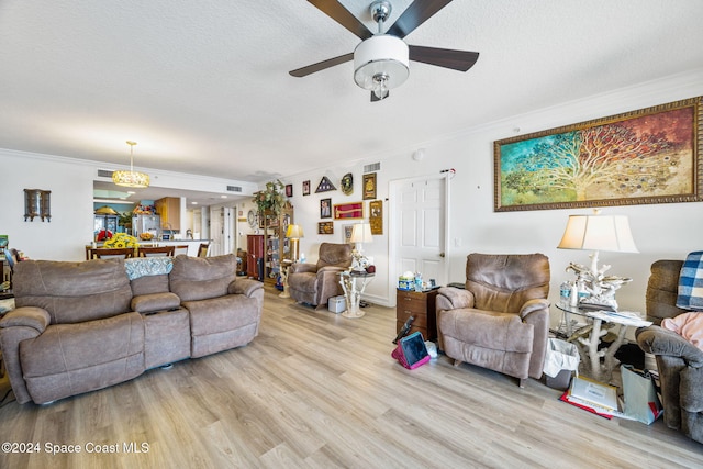 living room with a textured ceiling, light wood-type flooring, ceiling fan, and ornamental molding