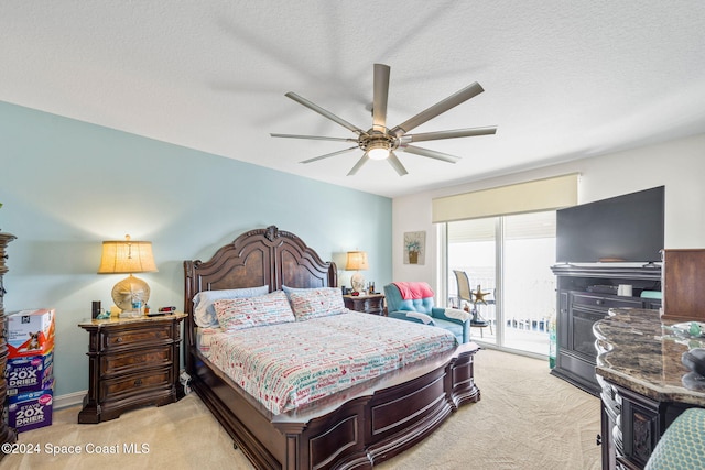 bedroom with access to outside, ceiling fan, light colored carpet, and a textured ceiling