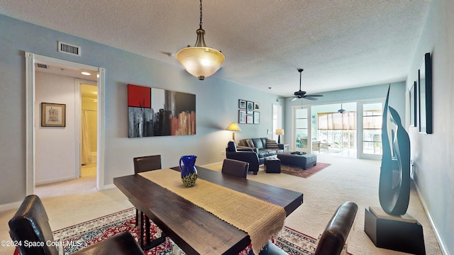 dining room featuring light carpet and a textured ceiling