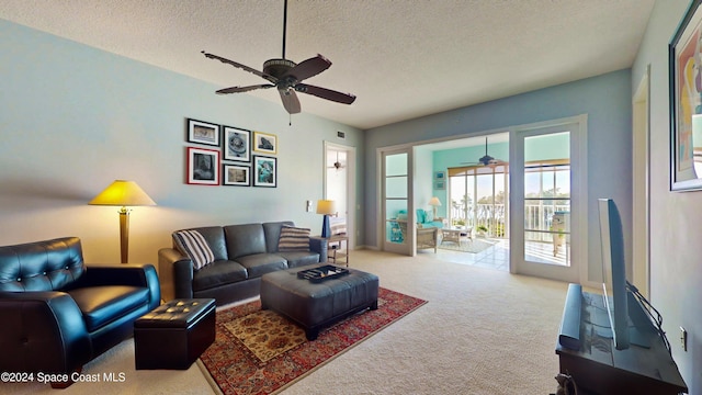 carpeted living room with ceiling fan and a textured ceiling