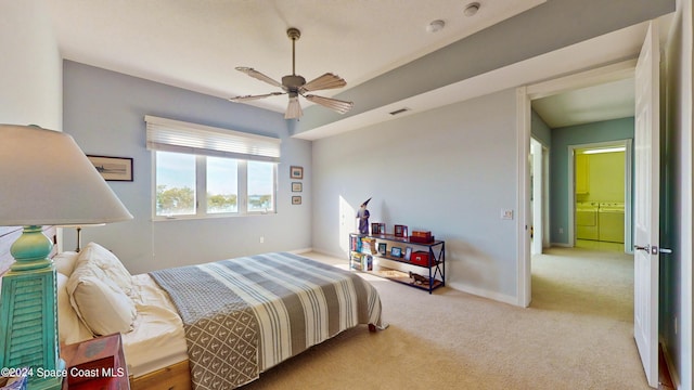 bedroom featuring light carpet, ceiling fan, and washing machine and clothes dryer