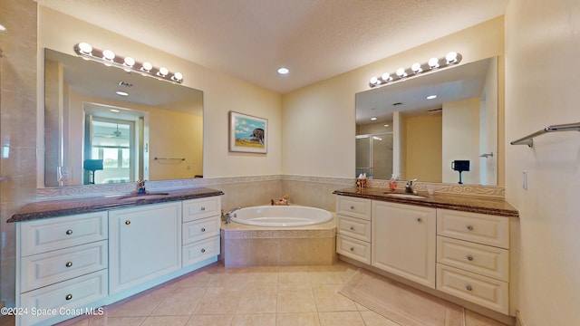 bathroom featuring tile patterned flooring, vanity, independent shower and bath, and a textured ceiling