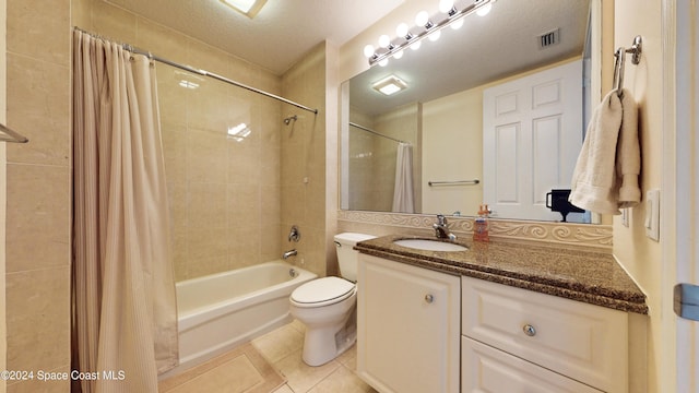 full bathroom with tile patterned floors, shower / bath combination with curtain, a textured ceiling, toilet, and vanity