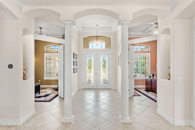 tiled foyer entrance featuring crown molding and decorative columns