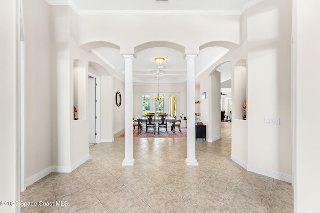 tiled entryway with decorative columns and ornamental molding