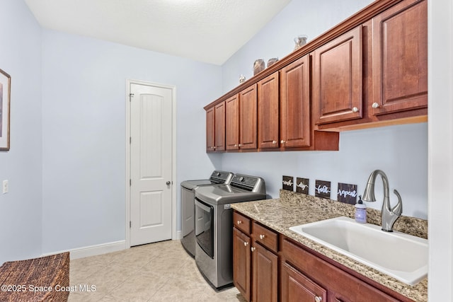 washroom featuring cabinets, separate washer and dryer, sink, and light tile patterned floors