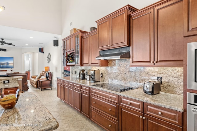 kitchen featuring tasteful backsplash, light tile patterned floors, ceiling fan, light stone counters, and black electric cooktop