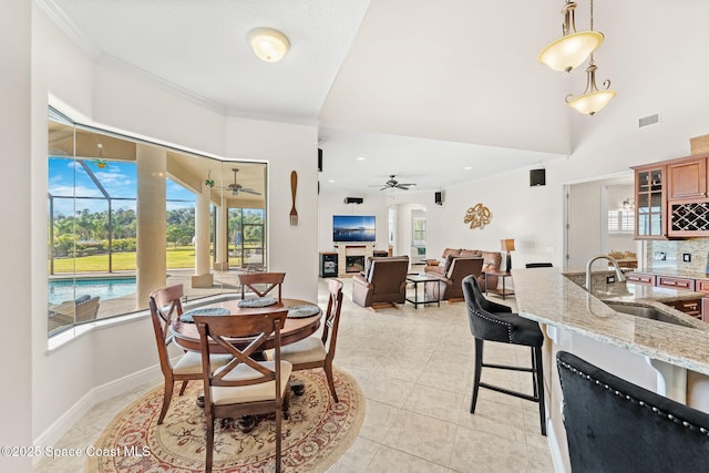 dining space featuring light tile patterned flooring, sink, ceiling fan, and crown molding