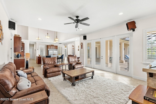 tiled living room with crown molding, ceiling fan, and french doors