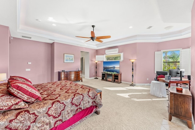 bedroom featuring a raised ceiling, light carpet, a wall mounted air conditioner, and ceiling fan