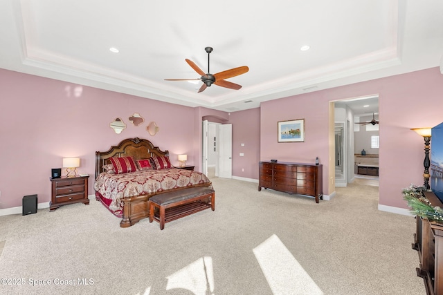 carpeted bedroom featuring a raised ceiling and ceiling fan