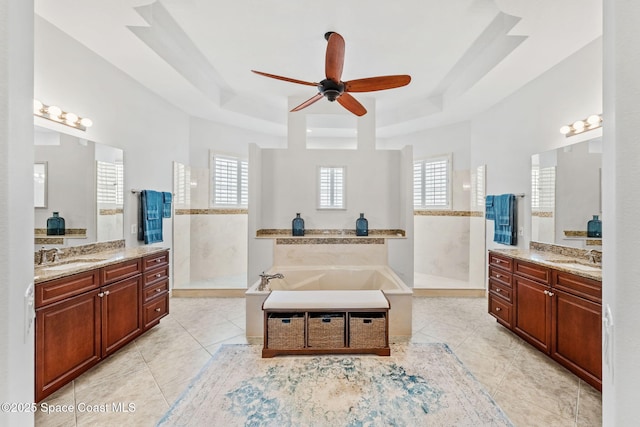 bathroom with shower with separate bathtub, plenty of natural light, and a tray ceiling