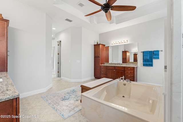 bathroom featuring vanity, a raised ceiling, a tub, ceiling fan, and tile patterned flooring