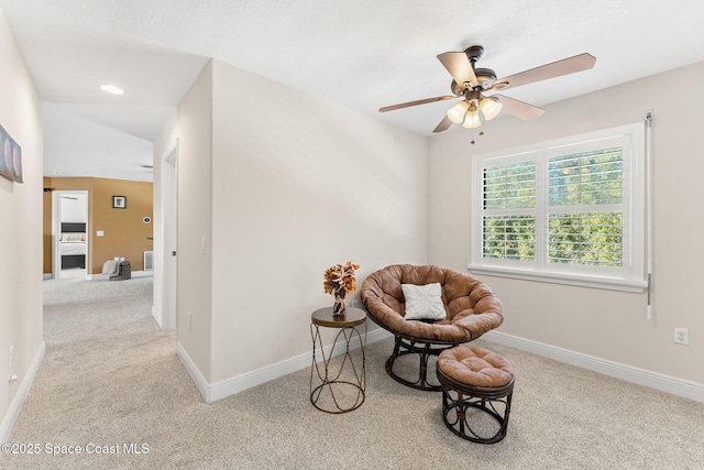 living area featuring light colored carpet and ceiling fan