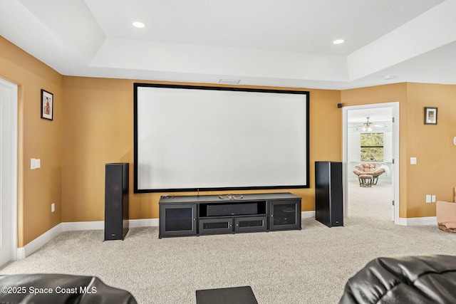 carpeted cinema room featuring a tray ceiling