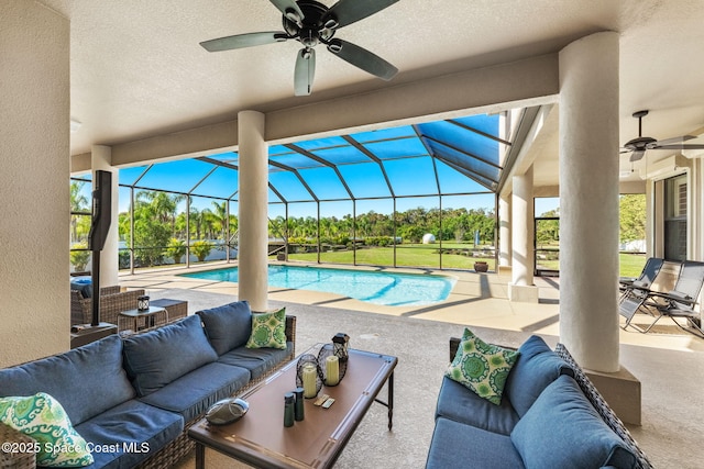 view of pool with a lanai, outdoor lounge area, a patio, and ceiling fan