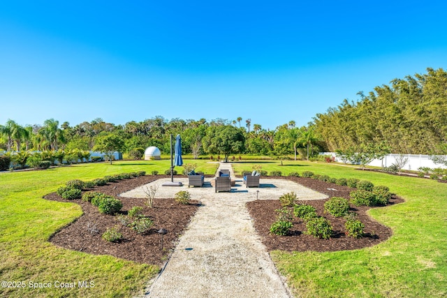 view of home's community with a patio area and a lawn