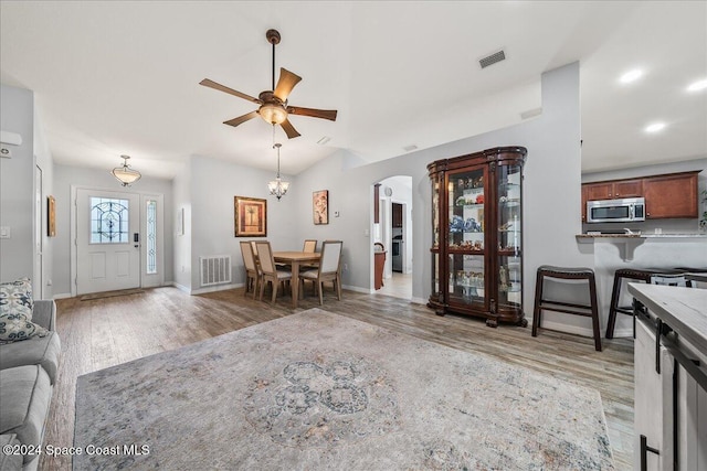 living room featuring ceiling fan, wood-type flooring, and lofted ceiling