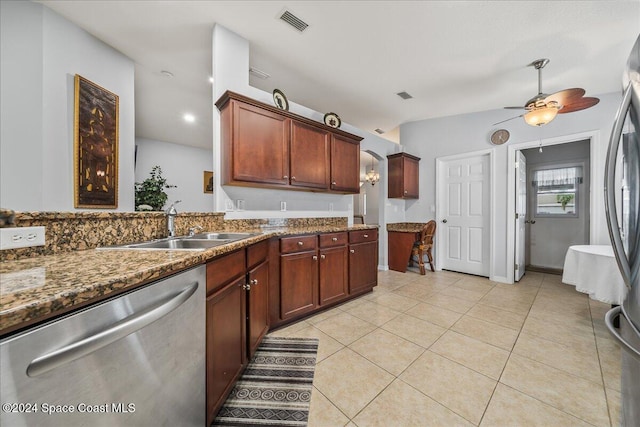 kitchen featuring appliances with stainless steel finishes, sink, dark stone counters, light tile patterned floors, and ceiling fan