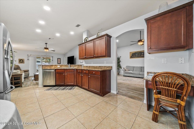 kitchen with kitchen peninsula, light tile patterned floors, ceiling fan, light stone counters, and stainless steel appliances