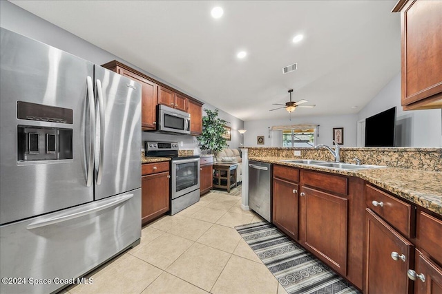 kitchen featuring light tile patterned flooring, sink, ceiling fan, stainless steel appliances, and light stone countertops