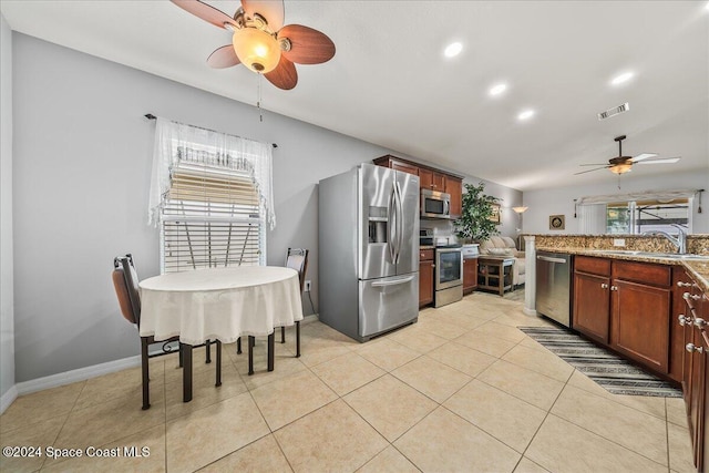 kitchen with light tile patterned floors, appliances with stainless steel finishes, sink, and plenty of natural light