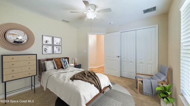 carpeted bedroom with ceiling fan and a closet