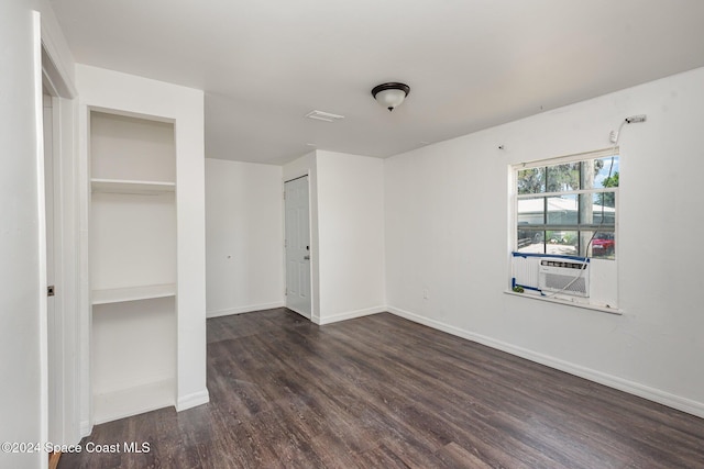 unfurnished bedroom featuring dark hardwood / wood-style flooring and cooling unit