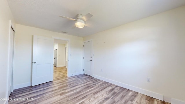 unfurnished bedroom featuring light wood-type flooring and ceiling fan