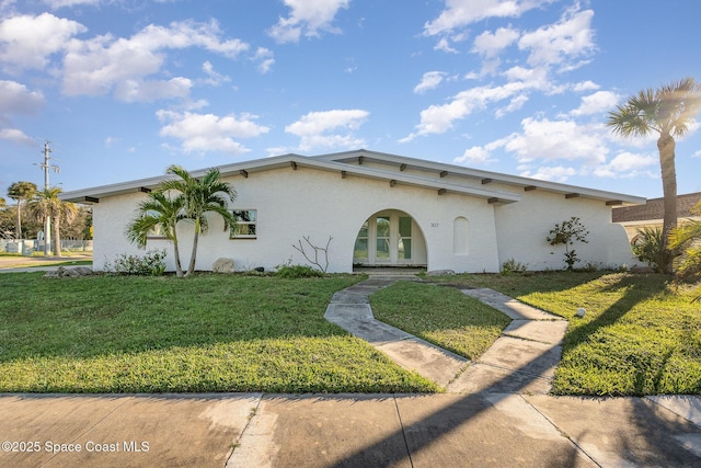 mediterranean / spanish-style house with french doors and a front lawn