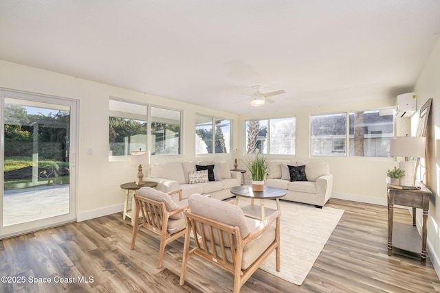 sunroom featuring a wall mounted AC and ceiling fan