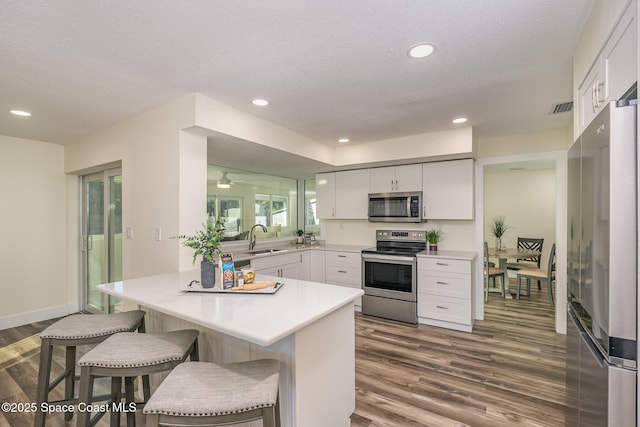 kitchen featuring white cabinets, a breakfast bar, sink, and stainless steel appliances