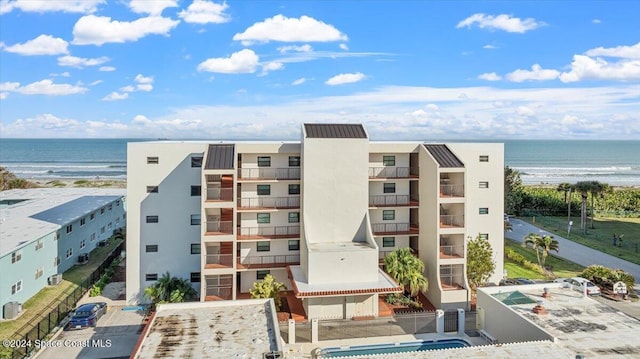 view of building exterior featuring a water view and a view of the beach