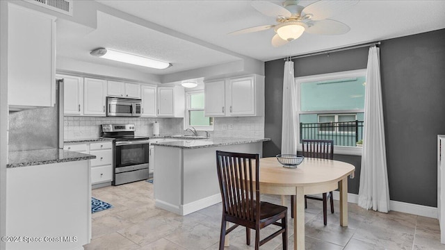 kitchen featuring light stone counters, white cabinets, and appliances with stainless steel finishes