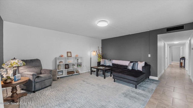 tiled living room featuring a textured ceiling