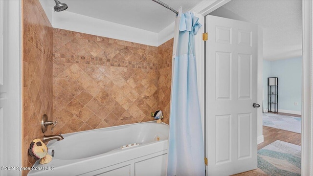 bathroom featuring hardwood / wood-style flooring and shower / bathtub combination with curtain