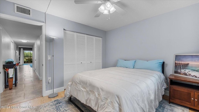 bedroom with light wood-type flooring, a closet, and ceiling fan